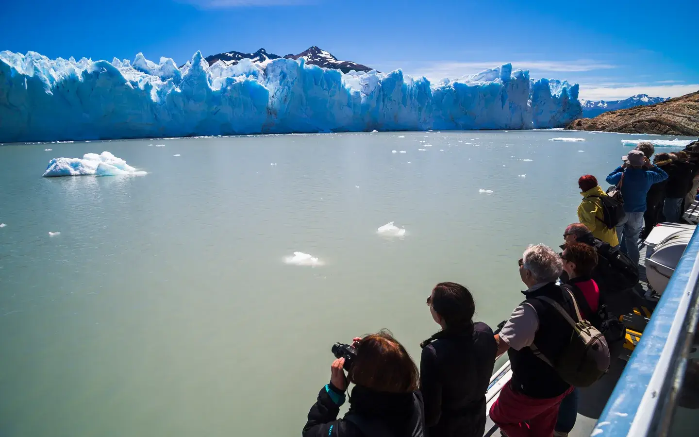 Travellers at the rail of a boat, looking at the Perito Moreno glacier in Patagonia, Argentina