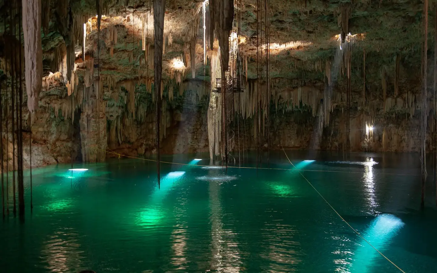 Crystal-clear turquoise cenote surrounded by limestone walls in the Yucatan