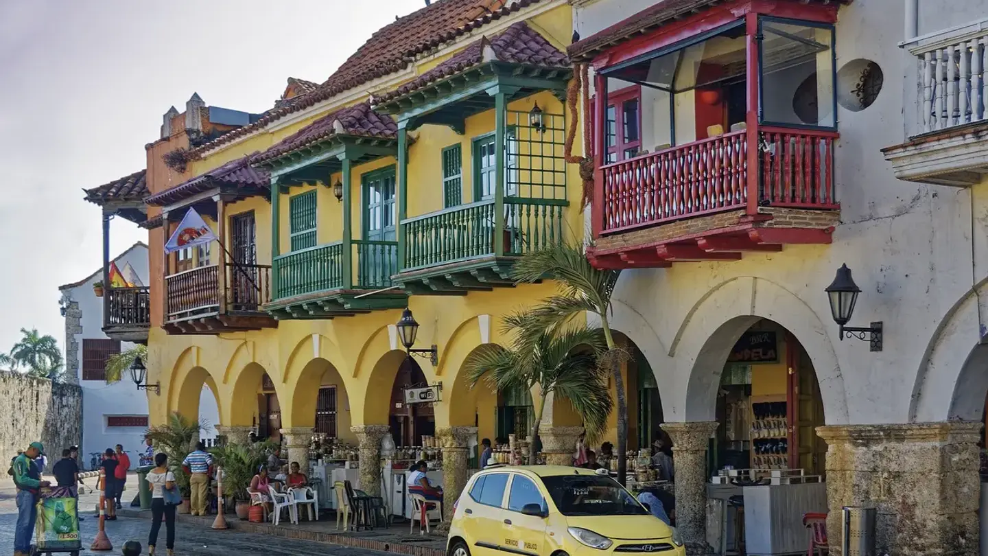 Colourful colonial buildings with wooden balconies and arches on a plaza in Cartagena, Colombia