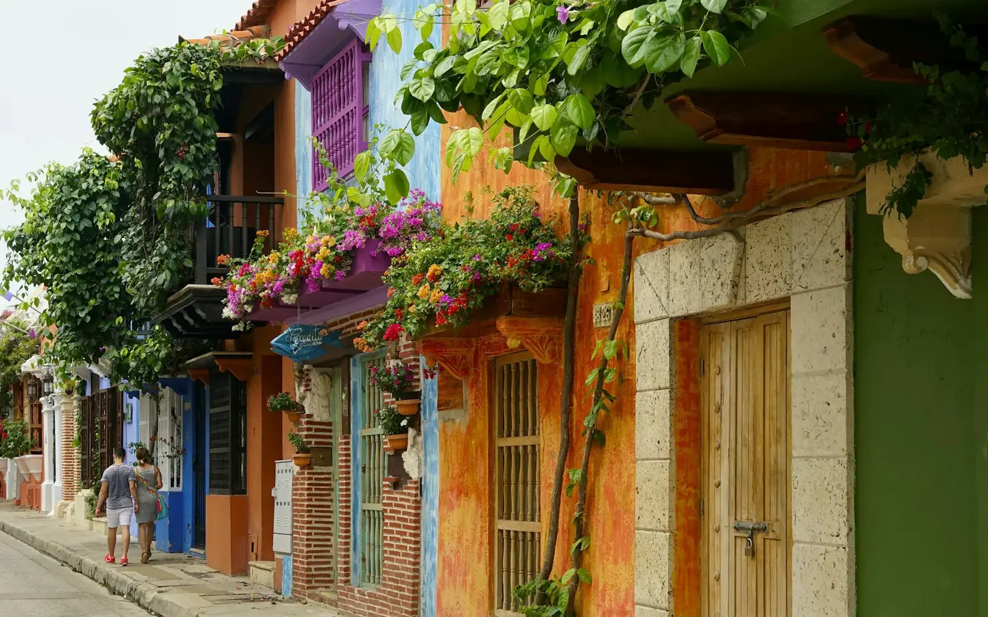 Colourful colonial buildings with flower-draped balconies on a street in Cartagena, Colombia