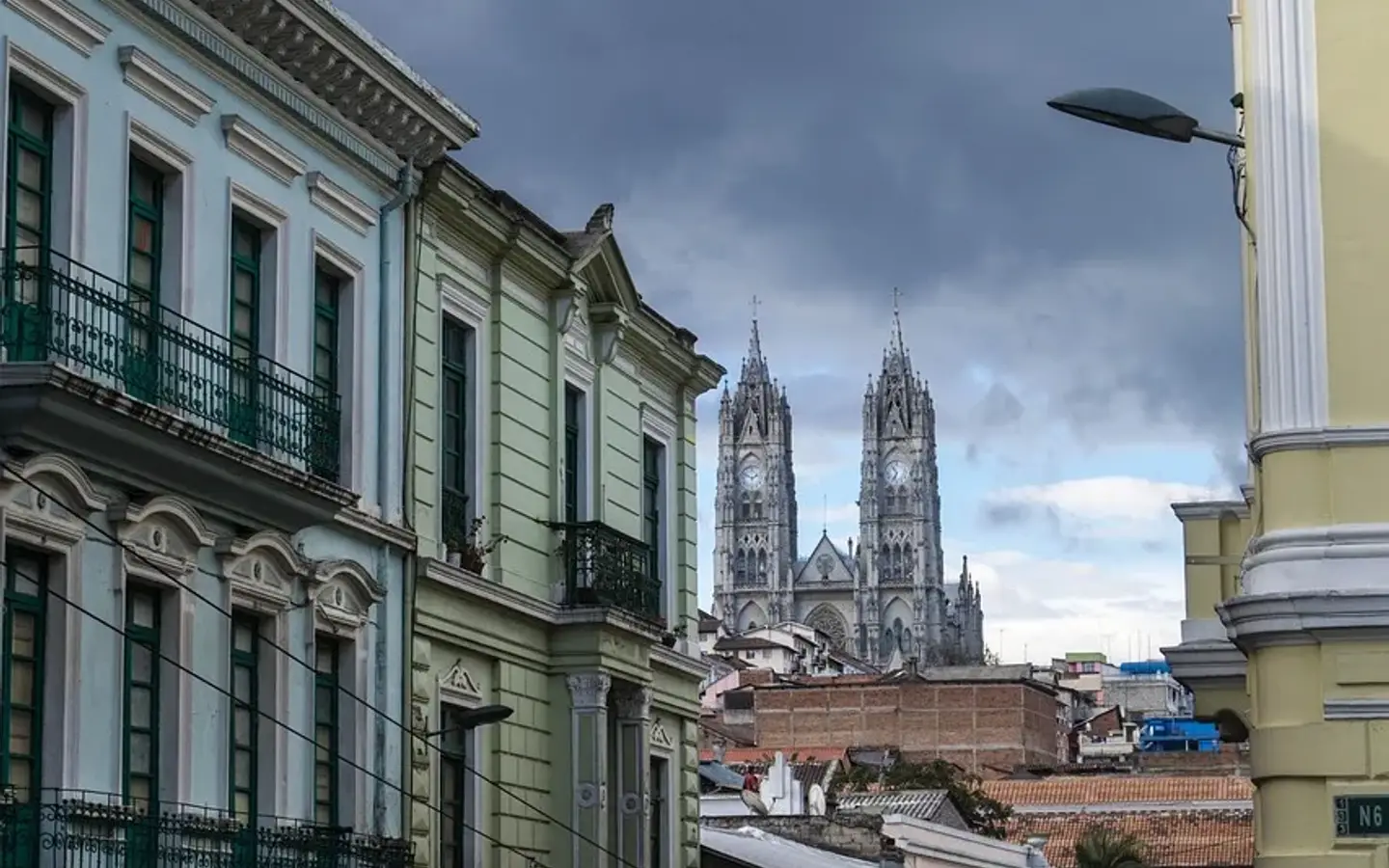 Colonial facades in Quito's old town with the towers of the Basílica del Voto Nacional behind, Ecuador