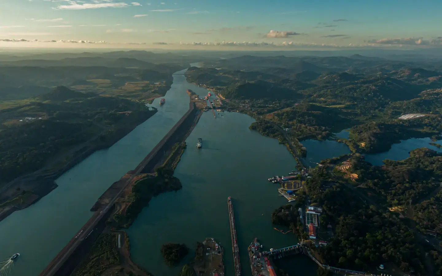 The Panama Canal winding through green hills past the Miraflores Locks, seen from the air