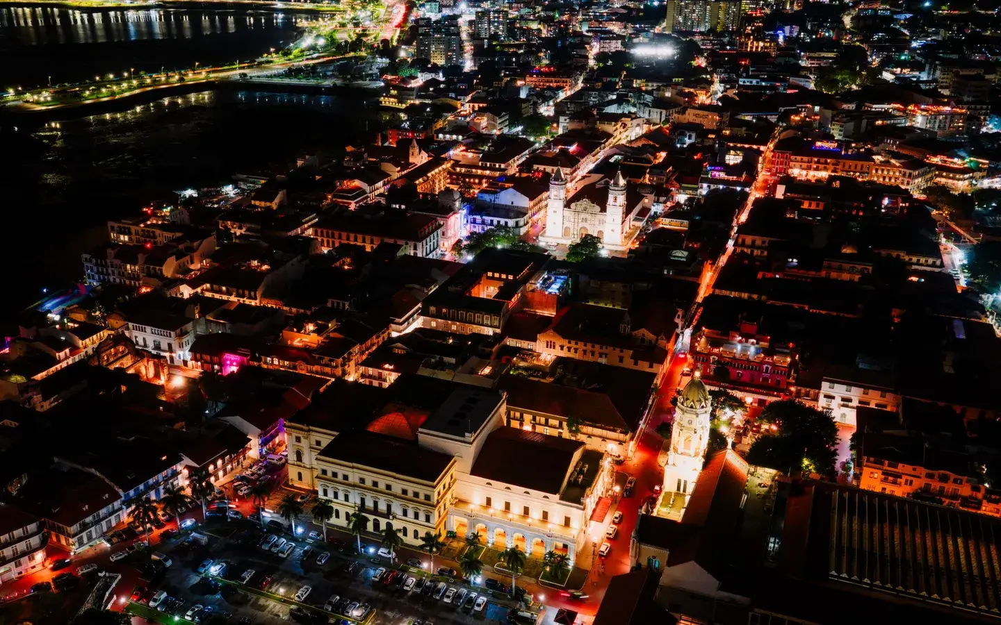 Aerial night view over the rooftops and lit streets of Casco Viejo, Panama City