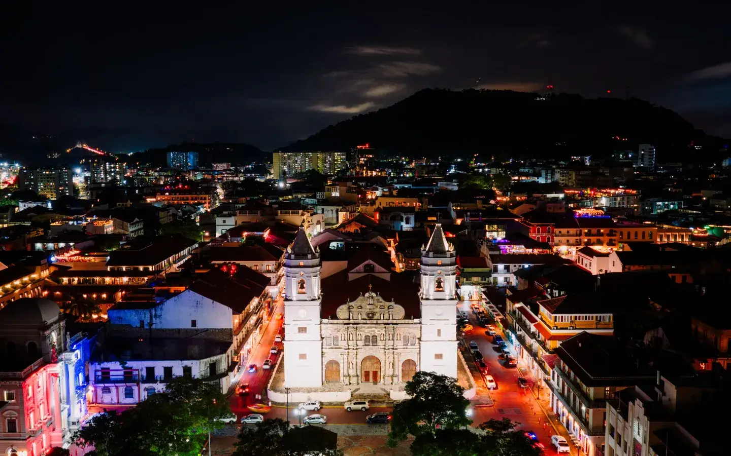 Casco Viejo cathedral lit up at night among red-tiled rooftops, Panama City