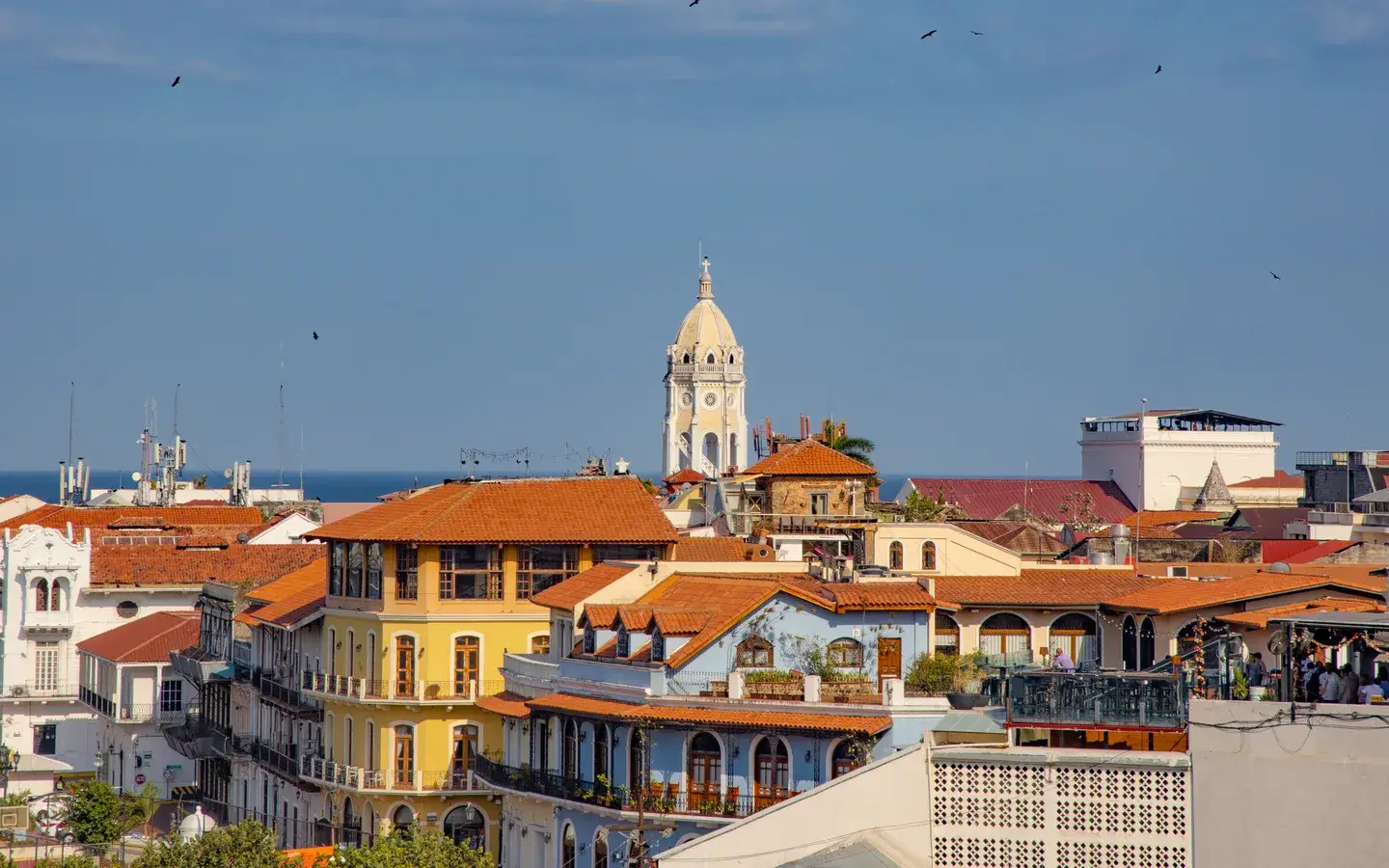 Red-tiled rooftops and the cathedral bell tower of Casco Antiguo under a blue sky, Panama City